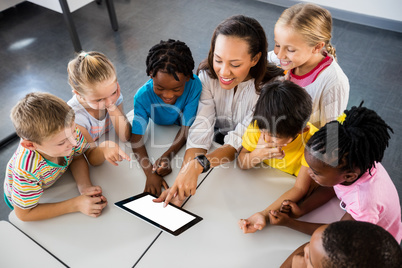 Happy teacher and pupils using tablet pc