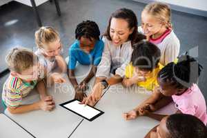 Happy teacher and pupils using tablet pc