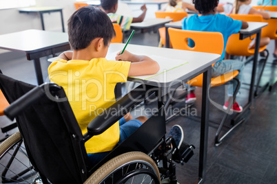 A pupil in wheel chair working at his desk
