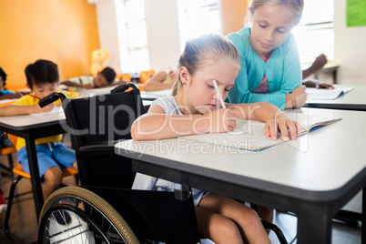 Pupil helping another at desk Pupil helping another at desk