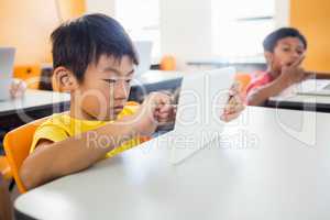 Little boy using tablet pc in classroom