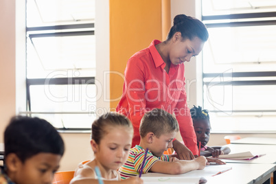 A teacher helping pupils in classroom A teacher helping pupils in classroom