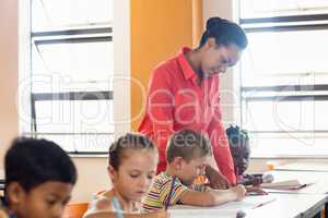 A teacher helping pupils in classroom