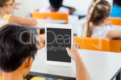 Rear view of pupils using tablet pc in classroom