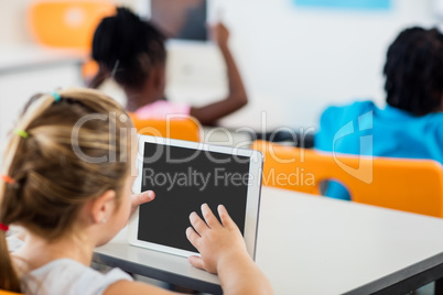 Rear view of pupil using tablet pc in classroom