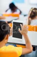 Rear view of pupil using tablet pc in classroom