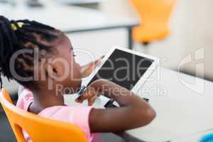 Side view of pupil using tablet pc in classroom