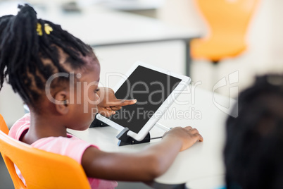 Side view of pupil using tablet pc in classroom