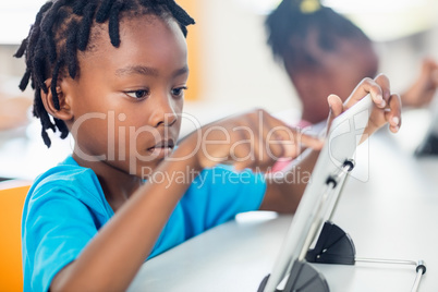 Close up view of pupil using tablet pc at desk