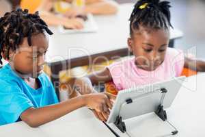 Two pupils using tablet pc at their desk