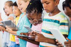 Close up view of pupils standing using tablet pc
