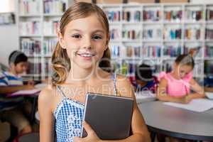 A cute little girl smiling at the camera with tablet pc