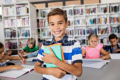 Little boy standing with notebooks