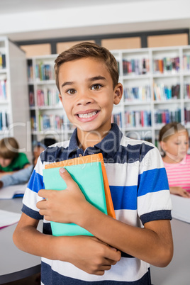 Little boy standing with notebooks