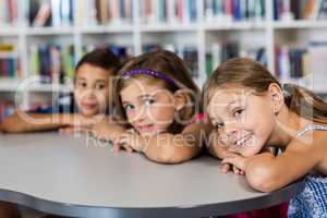 three pupils posing for the camera at desk