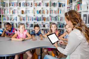 Teacher using tablet with pupils