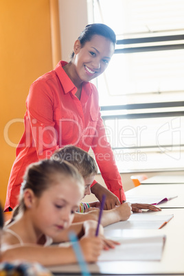 Teacher standing and posing while pupils are working