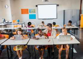 Children using technology with their teacher