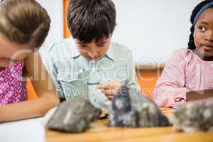 Children looking fossils with a magnifying glass