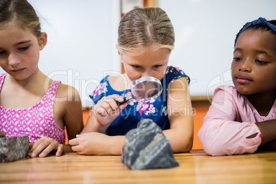 Children looking fossils with a magnifying glass