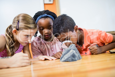 Children looking fossils with a magnifying glass