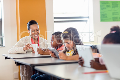 Teacher giving lesson to her students with technology