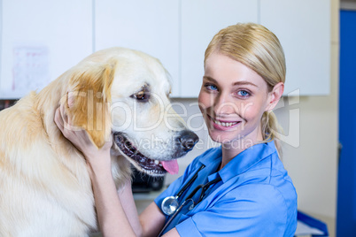 A smiling vet petting a dog