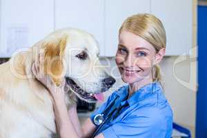 A smiling vet petting a dog