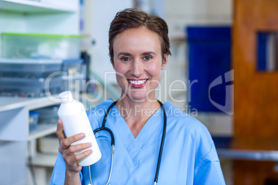 Portrait of woman vet bringing a bottle