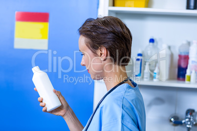 A woman vet reading the bottle instructions
