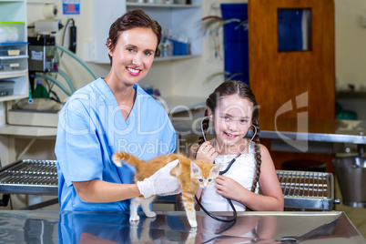 Portrait of woman vet and little girl bringing a kitten