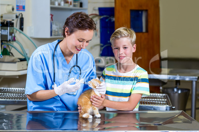 A woman vet examining a kitten with a little boy
