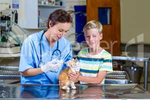 A woman vet examining a kitten with a little boy