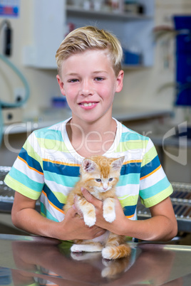 Portrait of little boy bringing a kitten