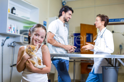 A little girl bringing a kitten