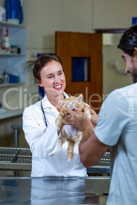 A woman vet giving kitten back to her customer