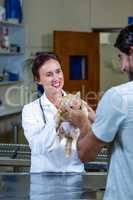 A woman vet giving kitten back to her customer