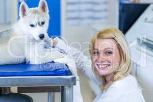 Portrait of woman vet squatting in front of a puppy