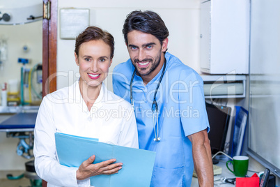 Portrait of two vets smiling and studying documents