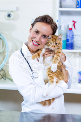 Portrait of woman vet giving a hug to a cat