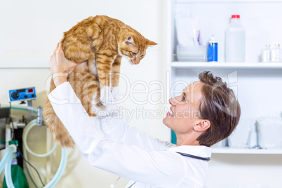 Woman vet smiling and holding a cat