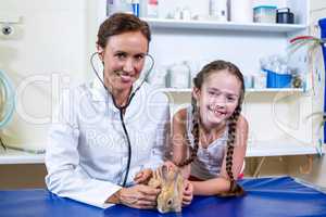Portrait of woman vet and little girl holing a rabbit