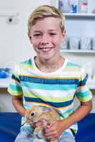 Portrait of little boy sitting and holding a rabbit