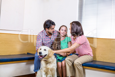 Family waiting on vet waiting room with their dog
