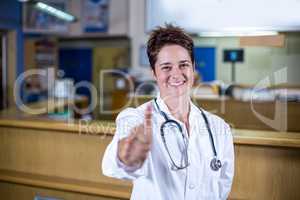 Portrait of woman vet smiling and throwing thumbs up