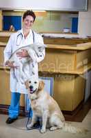 Woman vet smiling and posing with a cute puppy and a dog