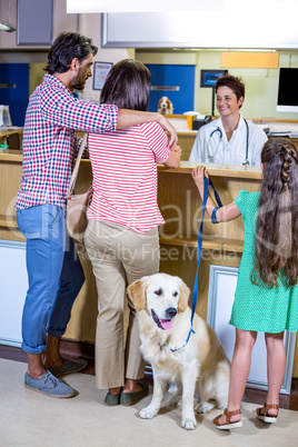 Family talking with smiling vet