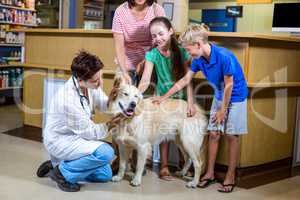 Woman vet examining dog with family
