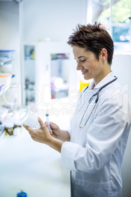 Woman vet smiling and preparing a syringe