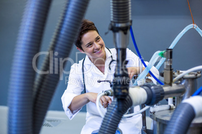 Woman vet smiling and posing behind medical machine